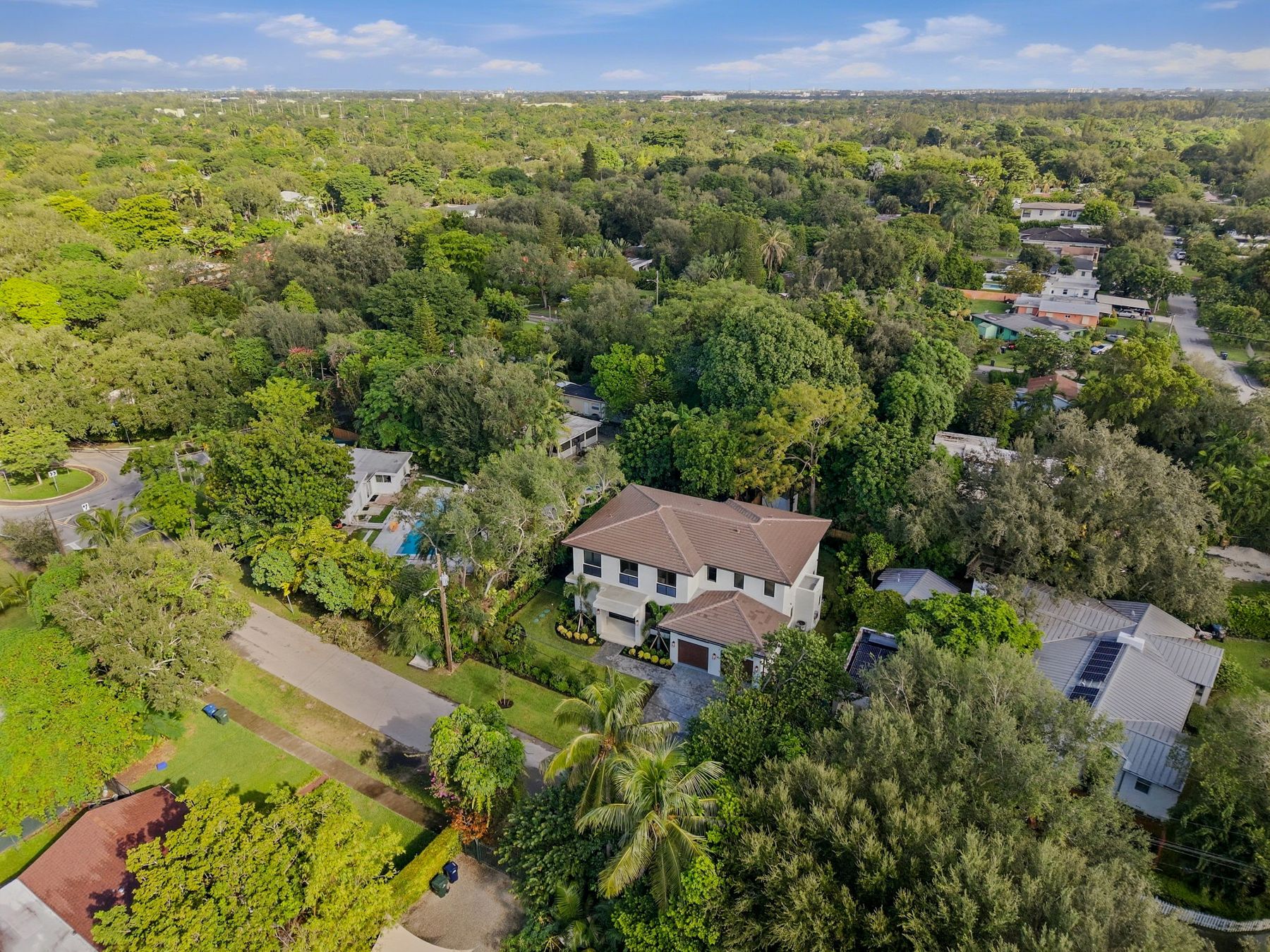 Aerial view of the home surrounded by mature tree canopy in Cocoplum Terrace